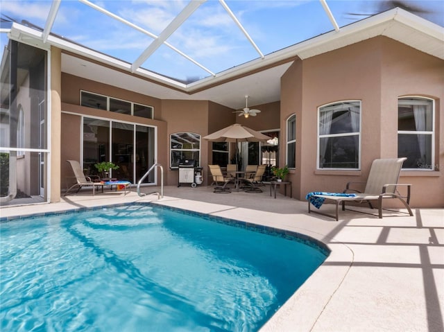 back of property with a patio area, stucco siding, an outdoor pool, and a ceiling fan