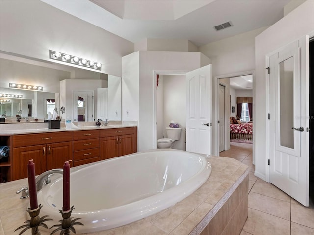 bathroom featuring vanity, visible vents, a garden tub, toilet, and tile patterned floors