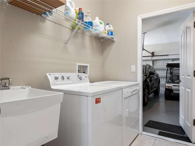 laundry area with laundry area, independent washer and dryer, and a sink