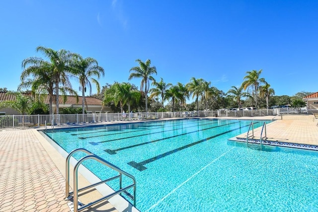 community pool with a patio and fence