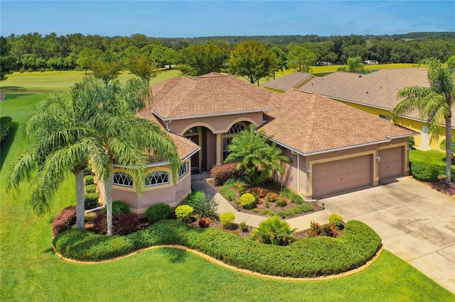 view of front of home with stucco siding, an attached garage, concrete driveway, and a shingled roof