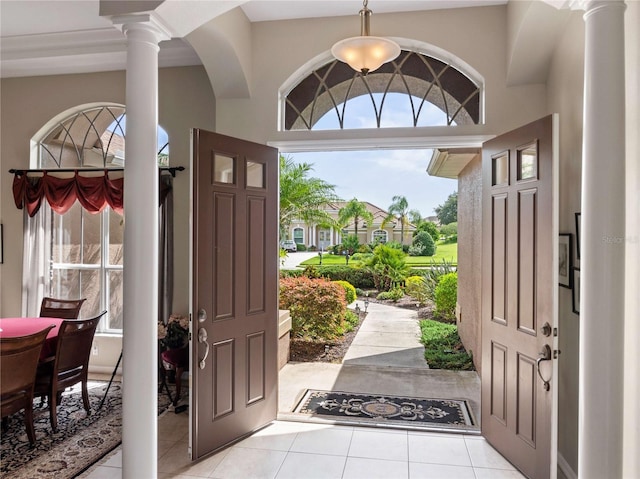 foyer featuring light tile patterned floors and ornate columns