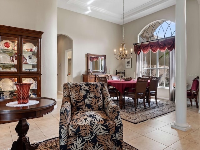 dining space featuring arched walkways, light tile patterned floors, a high ceiling, and an inviting chandelier