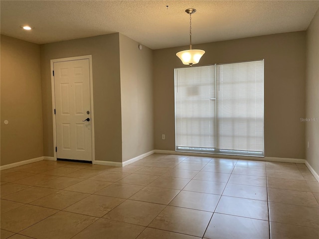 tiled spare room with a textured ceiling