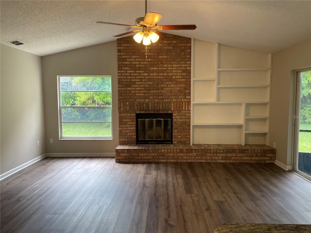 unfurnished living room with a brick fireplace, a textured ceiling, vaulted ceiling, and ceiling fan