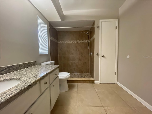 bathroom featuring tiled shower, vanity, toilet, and tile patterned floors