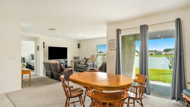 dining room with light carpet and a textured ceiling