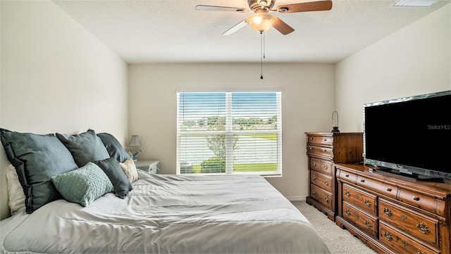 bedroom with a textured ceiling, carpet flooring, and ceiling fan