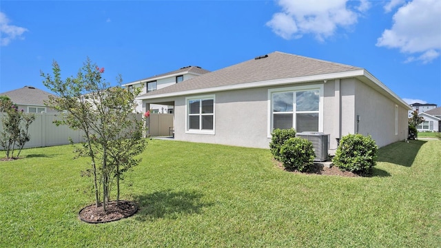 7774 Sail Clover Ln, Zephyrhills, FL 33540 - rear view of property with stucco siding, a shingled roof, central AC unit, and fence