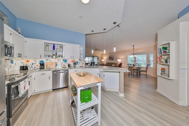 kitchen featuring white cabinets, a textured ceiling, stainless steel appliances, and a kitchen island