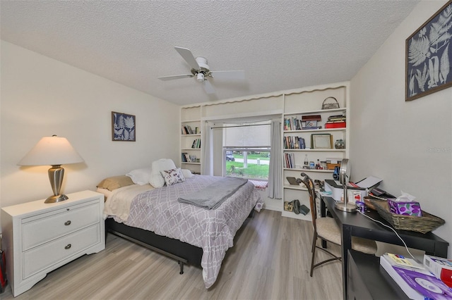 bedroom with ceiling fan, light hardwood / wood-style flooring, and a textured ceiling