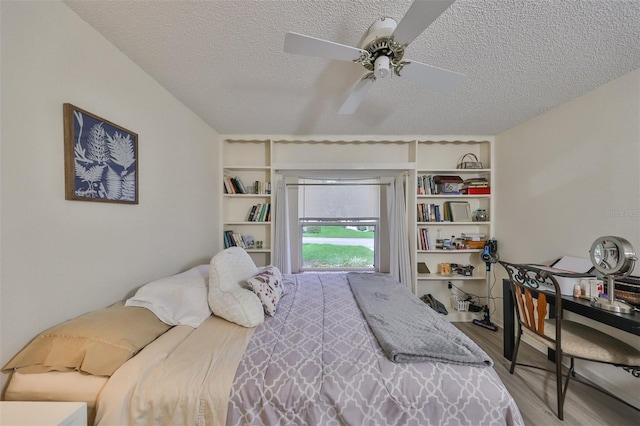 bedroom with a textured ceiling, light wood-type flooring, and ceiling fan