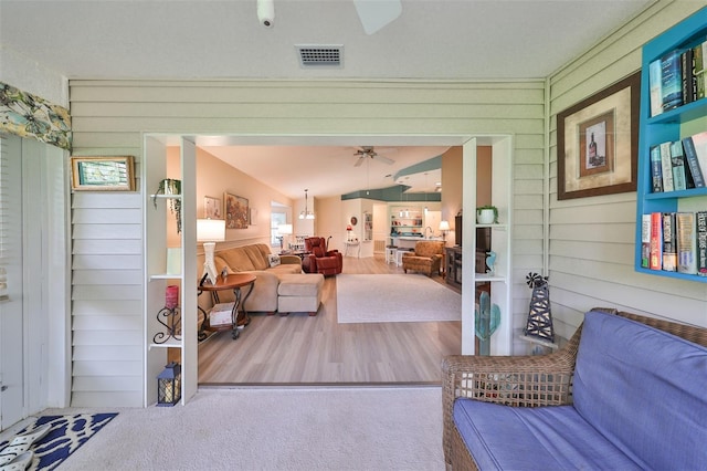 interior space featuring hardwood / wood-style floors, lofted ceiling, and wooden walls