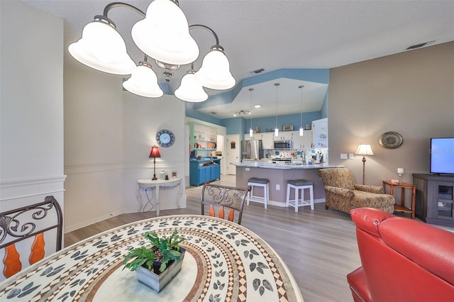 dining area featuring hardwood / wood-style flooring and a textured ceiling