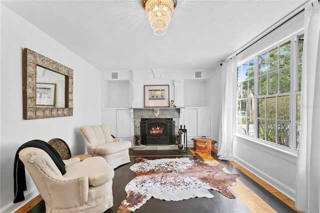 sitting room with wood-type flooring, a fireplace, and a healthy amount of sunlight