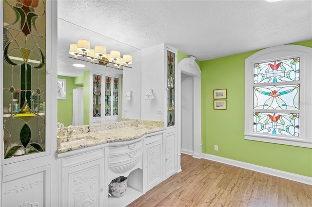 bathroom featuring a textured ceiling, hardwood / wood-style flooring, and vanity