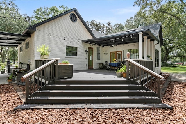 rear view of property featuring a wooden deck