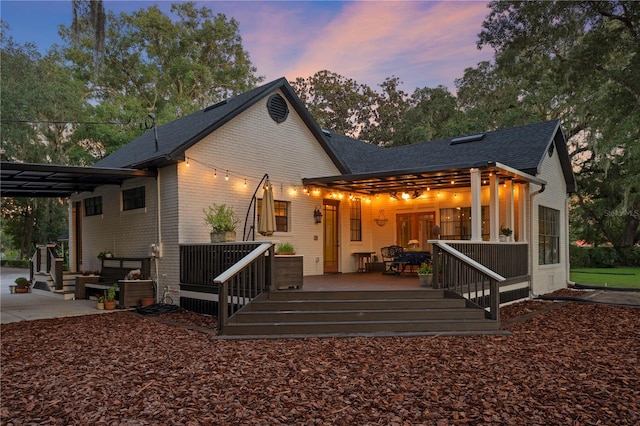 back house at dusk with a deck