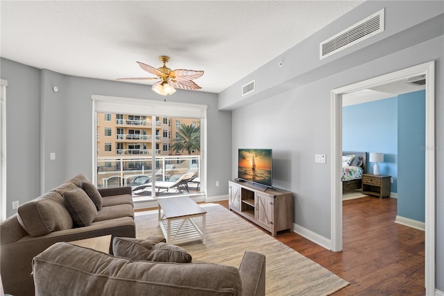 living room featuring a textured ceiling, hardwood / wood-style floors, and ceiling fan