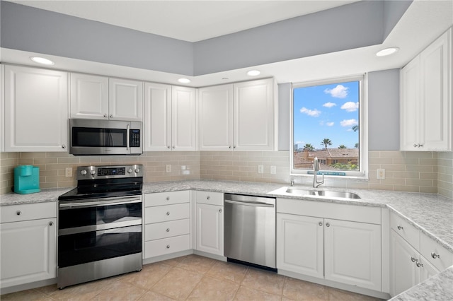 kitchen with appliances with stainless steel finishes, white cabinetry, and sink