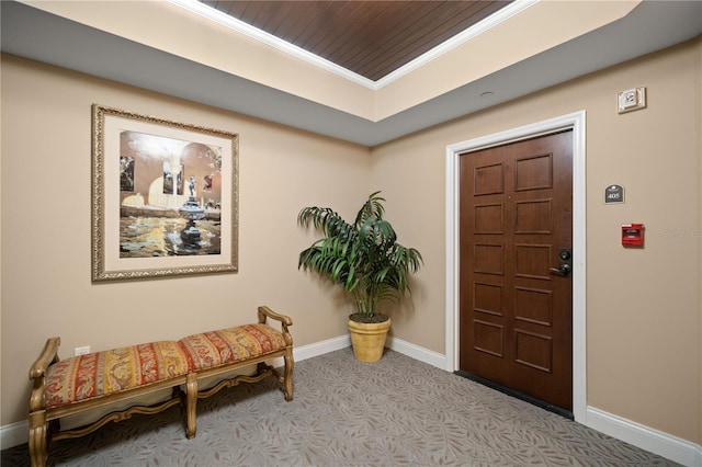 carpeted entryway with ornamental molding