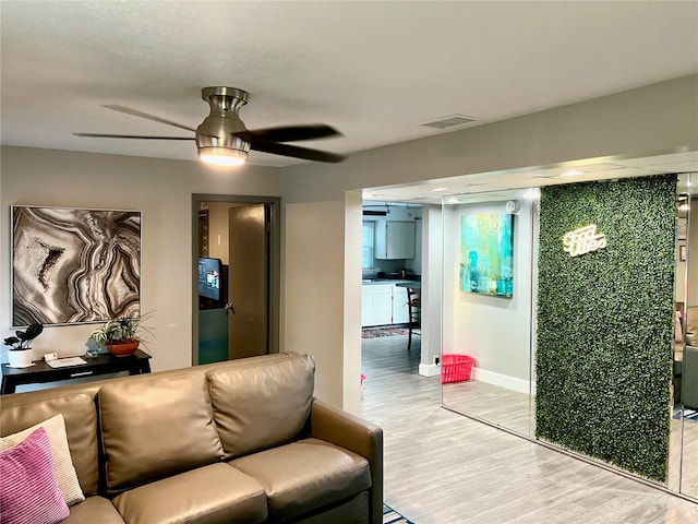 living room with ceiling fan and light wood-type flooring