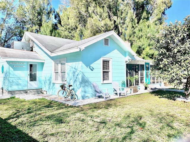1478 Alternate Keene Rd, Largo, FL 33771 - rear view of property with a lawn and a sunroom