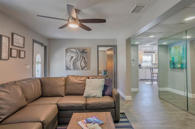 living room with sink, ceiling fan, and light hardwood / wood-style floors