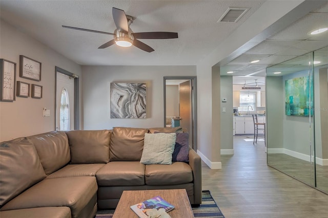 1478 Alternate Keene Rd, Largo, FL 33771 - living area with baseboards, a textured ceiling, visible vents, a ceiling fan, and wood finished floors