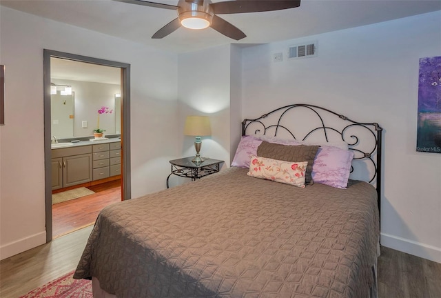 1478 Alternate Keene Rd, Largo, FL 33771 - bedroom featuring visible vents, baseboards, connected bathroom, wood finished floors, and ceiling fan