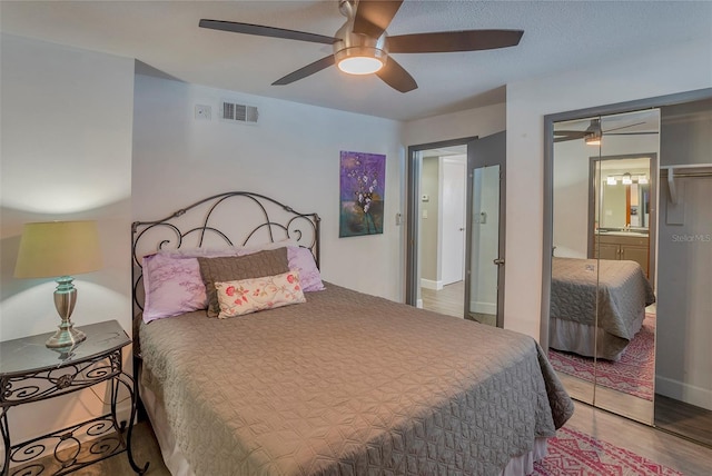 bedroom with light hardwood / wood-style flooring, sink, ceiling fan, and a closet