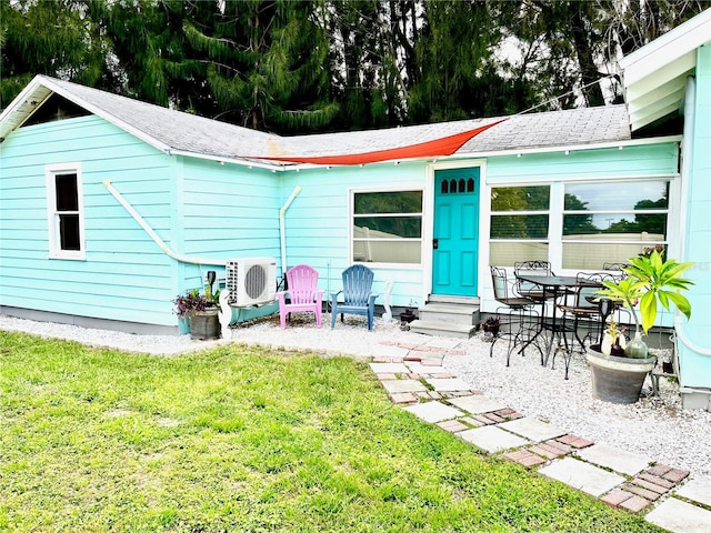 back of property featuring ac unit, a lawn, and a patio