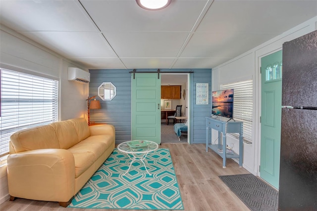 1478 Alternate Keene Rd, Largo, FL 33771 - living area with a wall mounted air conditioner, a barn door, wood walls, and light wood-type flooring