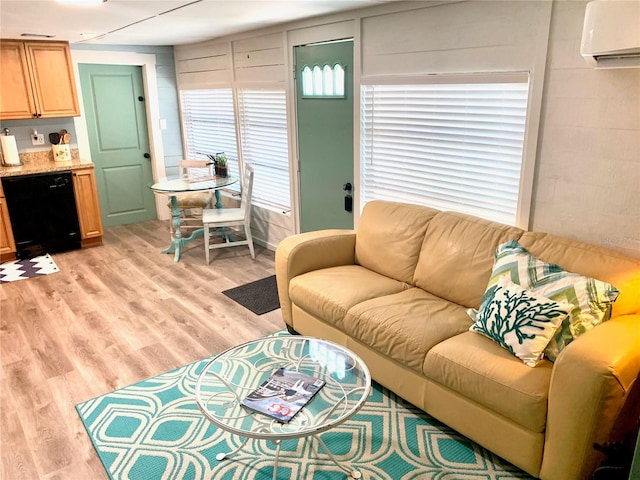 living room with a wall mounted AC and light hardwood / wood-style floors