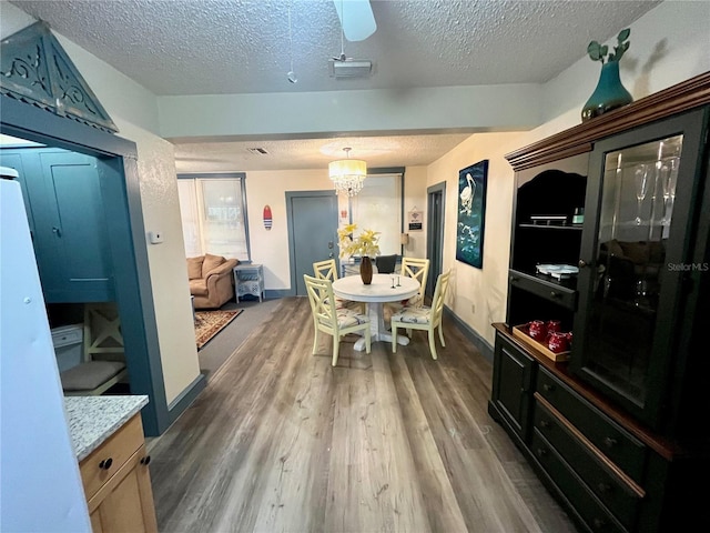 1478 Alternate Keene Rd, Largo, FL 33771 - dining room with visible vents, a textured ceiling, baseboards, and wood finished floors