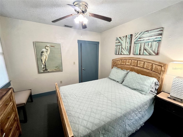 carpeted bedroom with ceiling fan and a textured ceiling