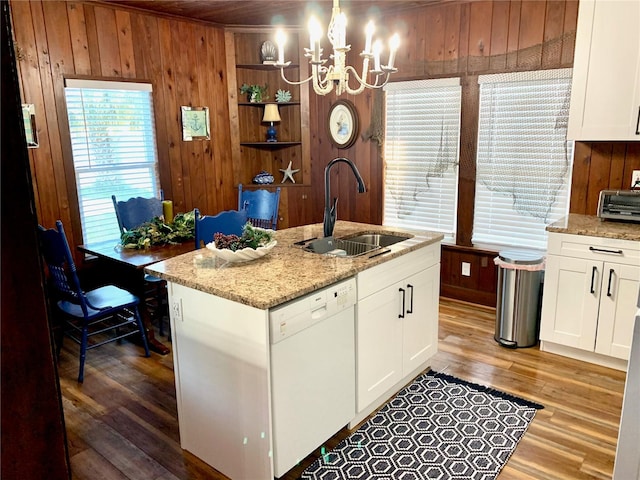 kitchen featuring dishwasher, wood walls, hardwood / wood-style flooring, and sink