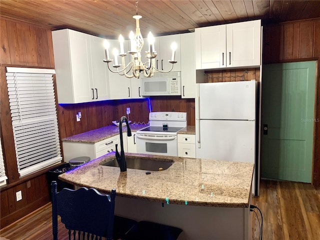 kitchen featuring decorative light fixtures, white appliances, dark hardwood / wood-style flooring, a chandelier, and white cabinets