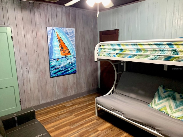 bedroom featuring light hardwood / wood-style flooring and wooden walls