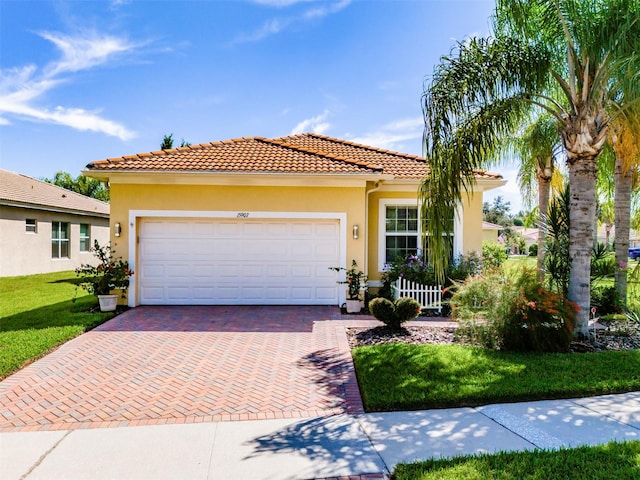 mediterranean / spanish-style house featuring a garage and a front lawn