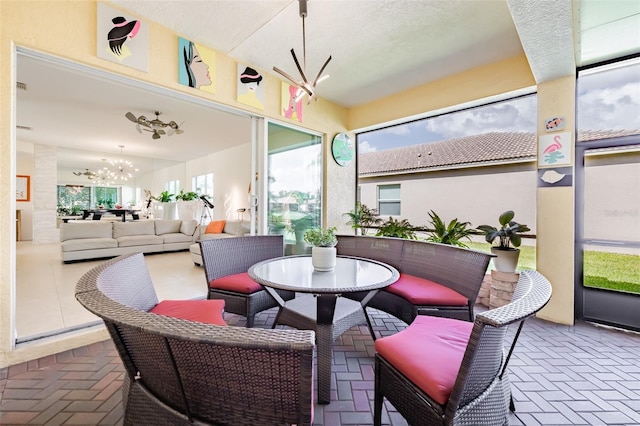 sunroom / solarium featuring a notable chandelier