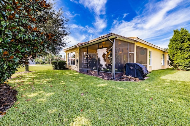 exterior space featuring a yard and a sunroom