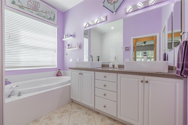 bathroom featuring tile patterned flooring, ceiling fan, tiled tub, and vanity