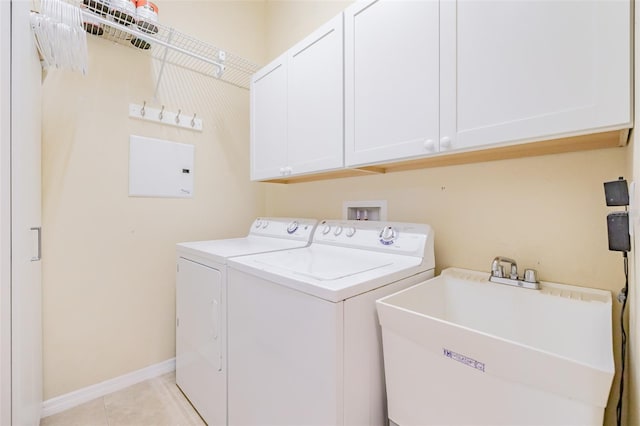 laundry room with light tile patterned floors, washer and dryer, cabinets, and sink