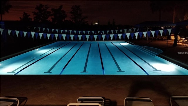 view of pool at twilight