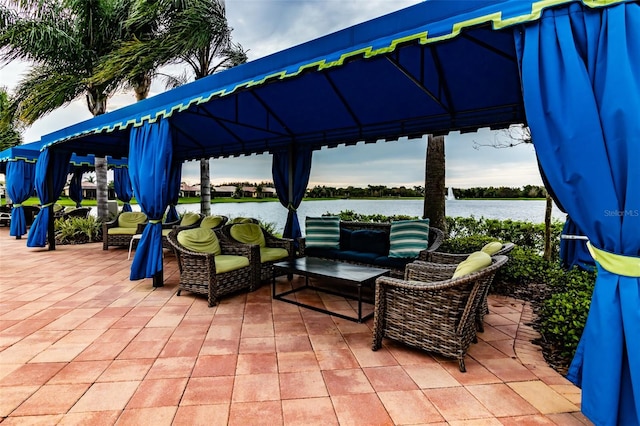 view of patio with a gazebo, outdoor lounge area, and a water view