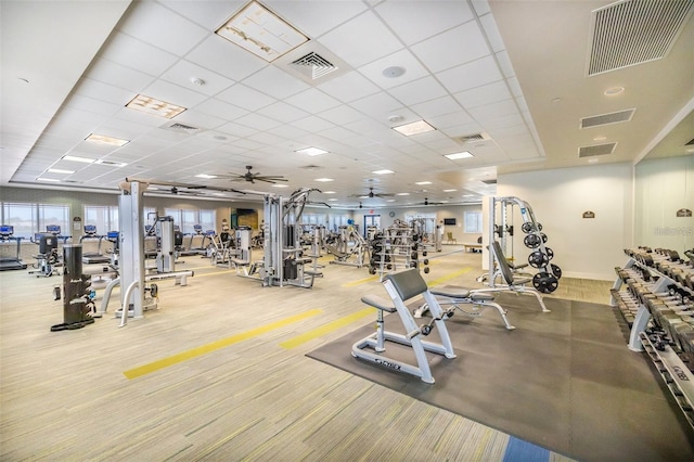 workout area featuring ceiling fan and a drop ceiling