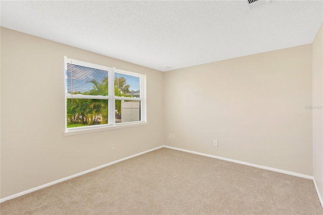 carpeted spare room featuring a textured ceiling