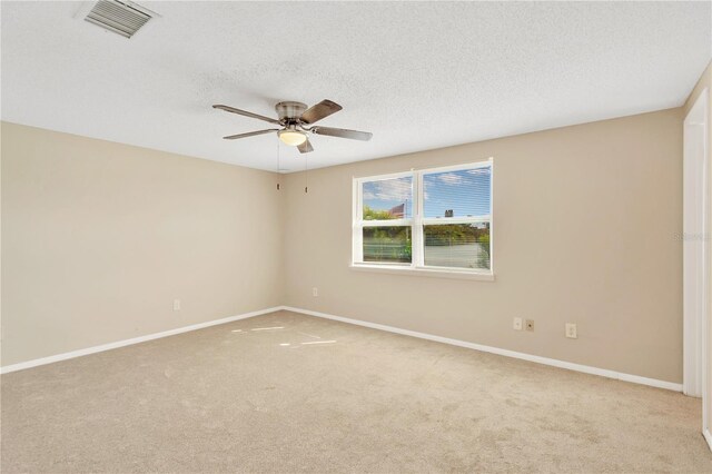 carpeted spare room featuring a textured ceiling and ceiling fan