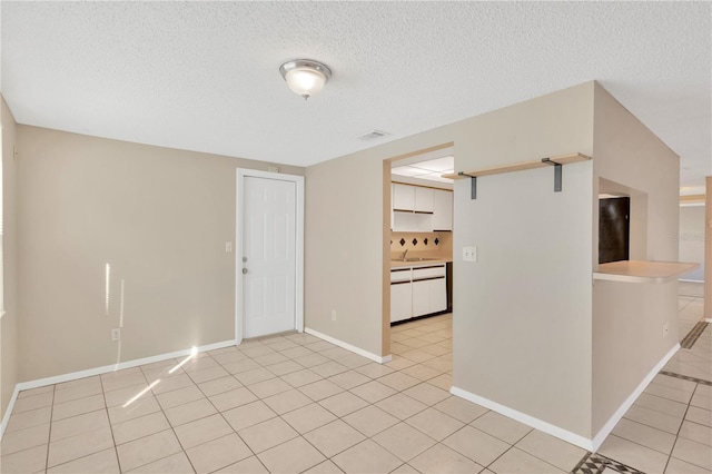 tiled spare room featuring a textured ceiling